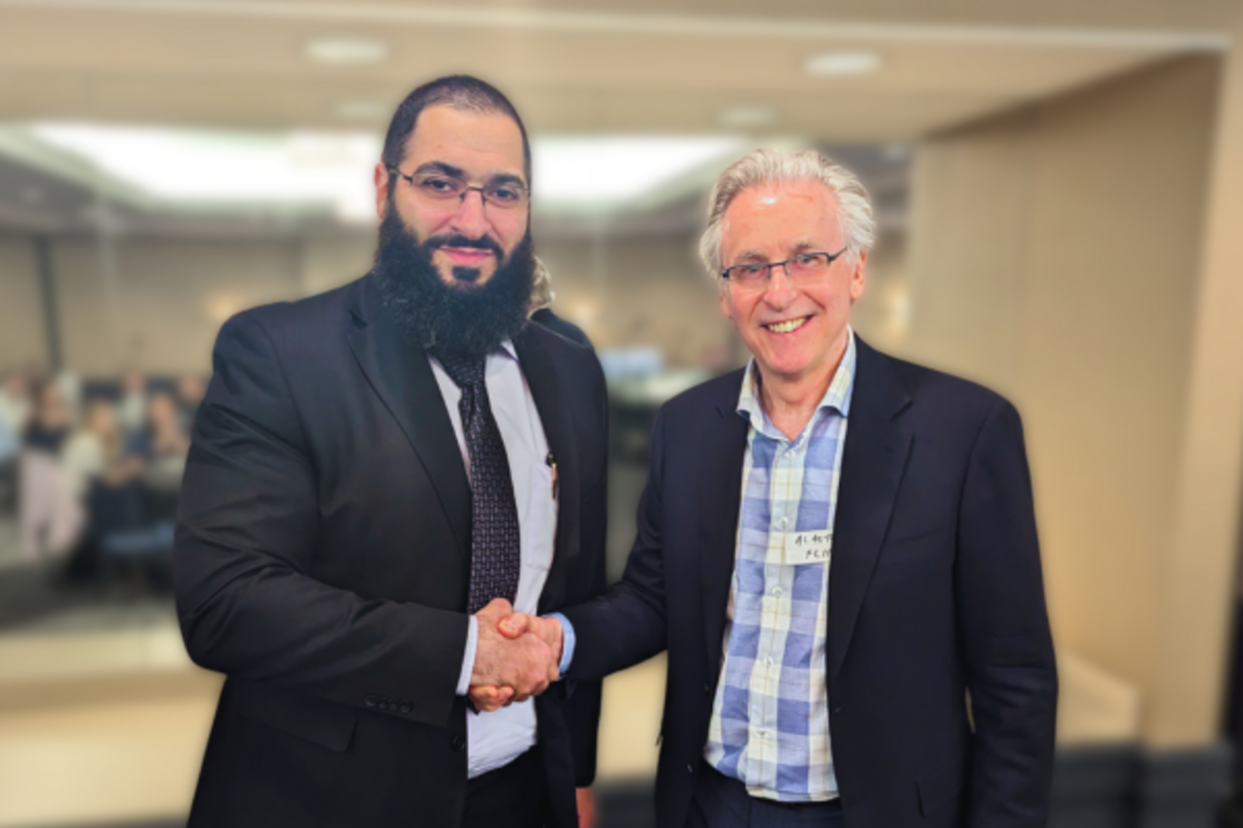 Dr. Ramzi Halabi shaking hands with Dr. Alastair Flint