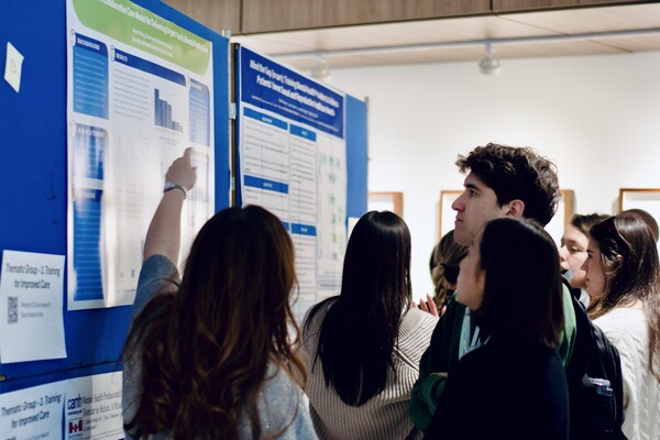 A group of learners discussing a poster board.