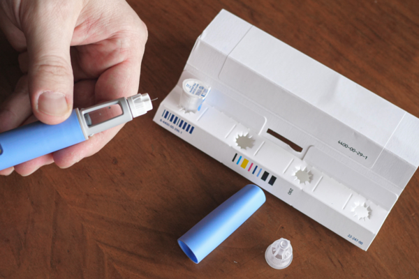 A person preparing a Semaglutide injection pen.