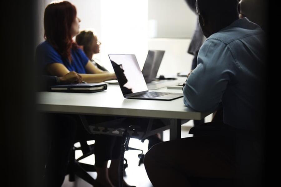 A group of people in a training, using laptops