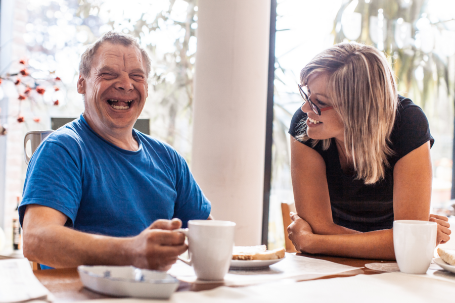 A older man and a middle-aged woman laugh together