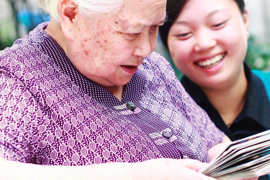 An older woman reading with her granddaughter