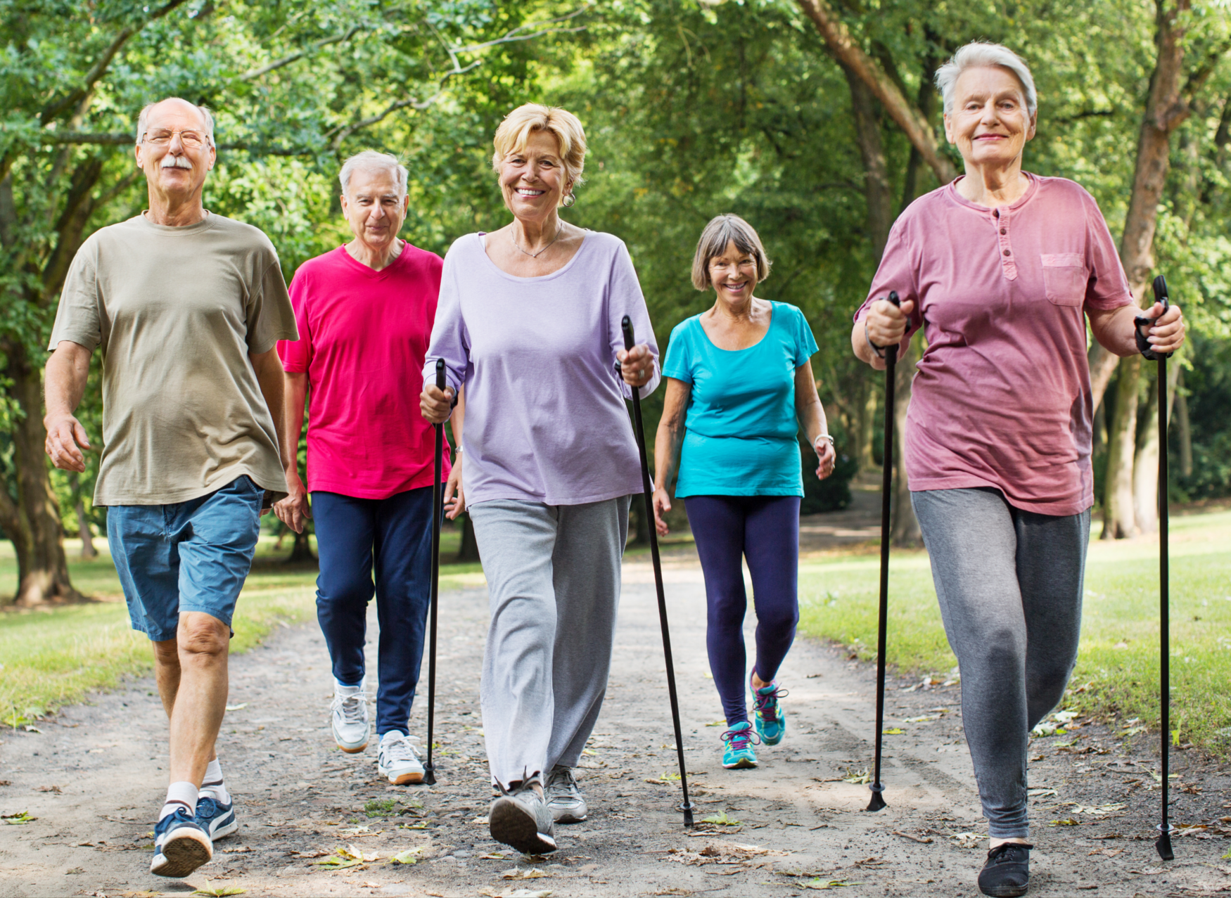 A group of individuals in mid- to late life walking together on a nature trail.