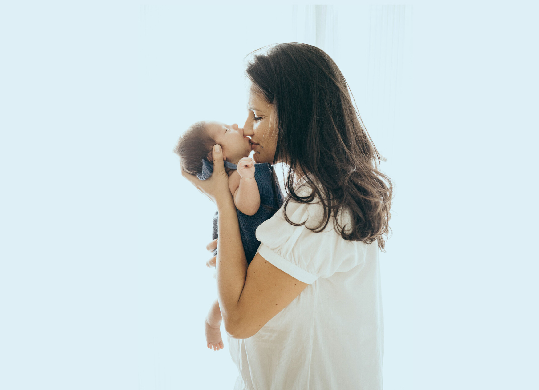 A woman holds a baby in her arms.