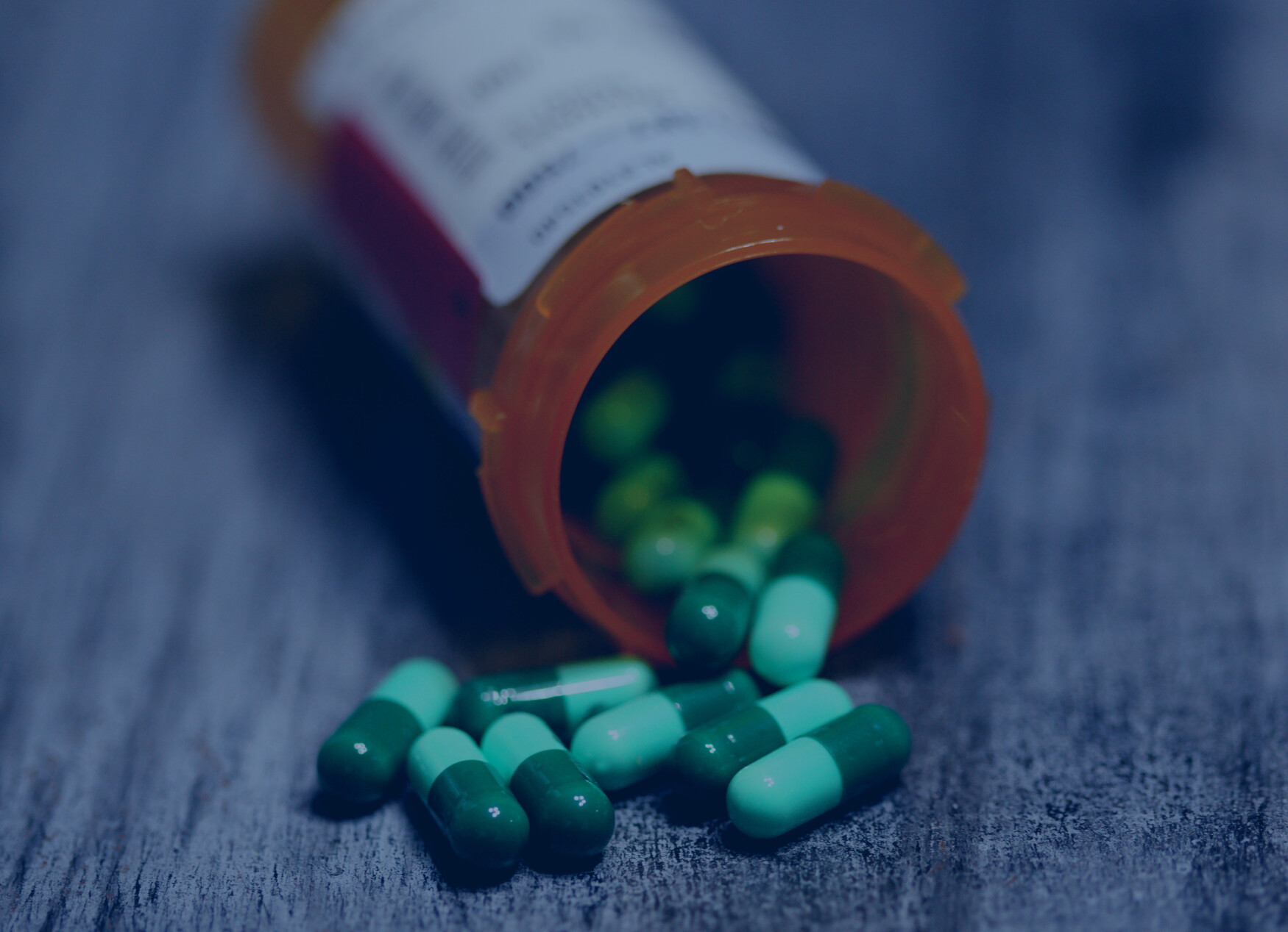 An open pill bottle lies on a table